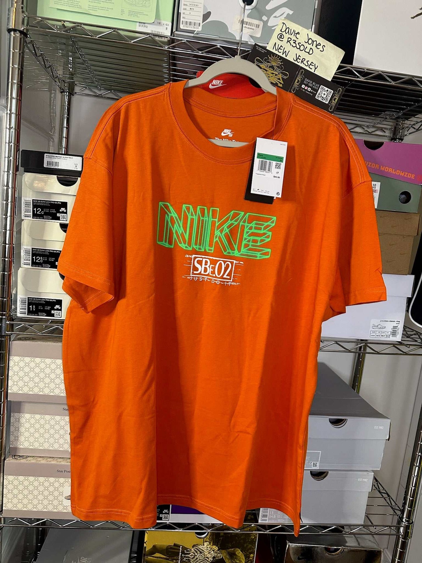 Orange Nike SB Y2K Tee, Size XL, deadstock, hanging on a rack.